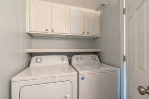 Laundry room with cabinet space and washer and clothes dryer