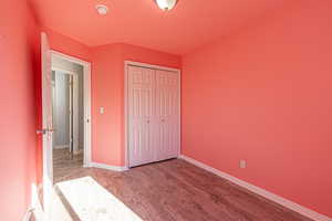 Unfurnished bedroom featuring wood finished floors and a closet