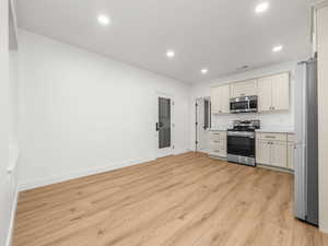 Kitchen with appliances with stainless steel finishes, light wood-type flooring, and recessed lighting