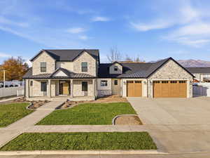 Modern farmhouse style home featuring covered porch, a standing seam roof, a metal roof, driveway, and a garage
