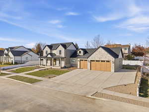 Modern farmhouse style home featuring a standing seam roof, concrete driveway, a metal roof, covered porch, and an attached garage