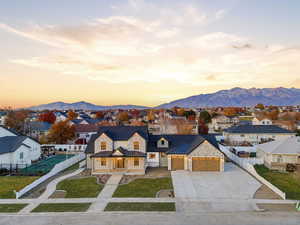 View of front of house with a residential view, concrete driveway, an attached garage, a standing seam roof, and a metal roof