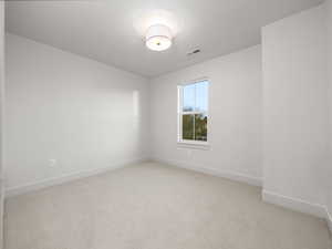Unfurnished room featuring light carpet and baseboards