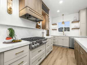 Kitchen featuring decorative light fixtures, open shelves, brown cabinets, tasteful backsplash, and light wood finished floors