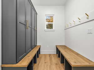 Mudroom with light wood-style flooring and baseboards
