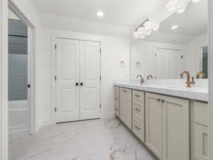 Full bathroom with double vanity, light marble finish floors, recessed lighting, and bathing tub / shower combination