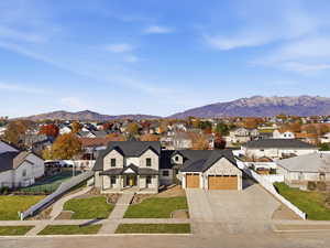 Modern farmhouse with concrete driveway, a mountain view, a garage, a residential view, and a metal roof