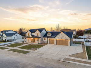 Modern farmhouse style home with covered porch, concrete driveway, a standing seam roof, a garage, and a metal roof