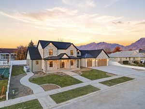 View of front of home featuring a porch, concrete driveway, a garage, a metal roof, and a standing seam roof