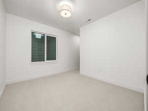 Spare room featuring carpet floors and baseboards