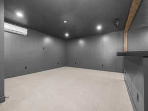 Finished below grade area with carpet, recessed lighting, and a wall mounted air conditioner