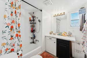 Bathroom with vanity and shower / tub combo with curtain