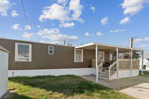 Manufactured / mobile home with covered porch and a front yard