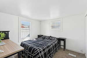 Carpeted bedroom with multiple windows