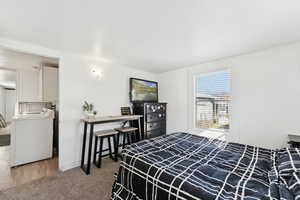 Carpeted bedroom with washer / dryer