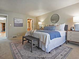 Bedroom featuring light carpet and connected bathroom
