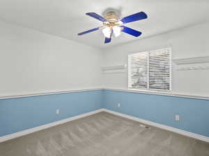 Empty room featuring carpet floors and ceiling fan