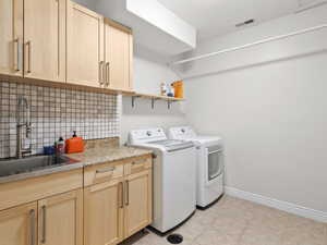 Laundry room featuring washing machine and clothes dryer and cabinet space
