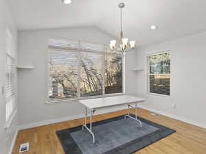 Dining room featuring light wood finished floors, a chandelier, recessed lighting, and lofted ceiling