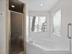 Master Bathroom with a garden tub, a shower stall,
