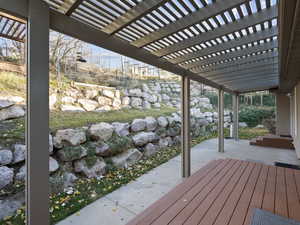 Wooden terrace featuring a pergola and a patio