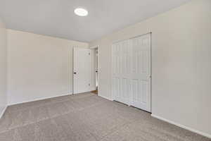 Unfurnished bedroom with carpet flooring and a closet