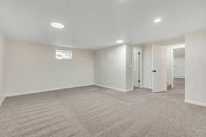 Below grade area with light carpet and recessed lighting