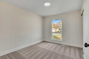 Unfurnished room with carpet and baseboards