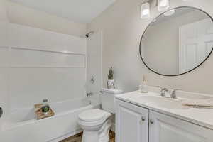 Full bath featuring vanity, shower / bath combination, and light wood-style flooring