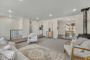 Living room featuring a wood stove, recessed lighting, and wood finished floors