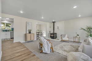 Living area with a wood stove, recessed lighting, and light wood-style flooring