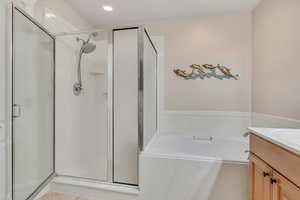 Bathroom with vanity, a bath, a shower stall, light tile patterned flooring, and recessed lighting