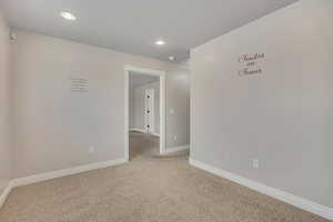Carpeted spare room featuring baseboards and recessed lighting