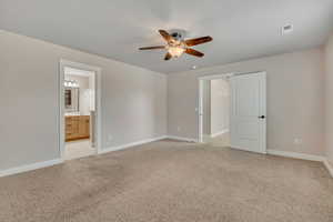 Unfurnished bedroom with light carpet, a ceiling fan, and ensuite bath