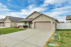 Ranch-style house with stucco siding, an attached garage, concrete driveway, brick siding, and a gate