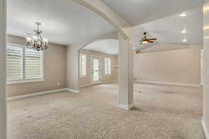 Unfurnished room featuring carpet floors, a chandelier, arched walkways, ceiling fan, and recessed lighting