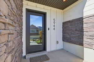 Doorway to property featuring stone siding and board and batten siding