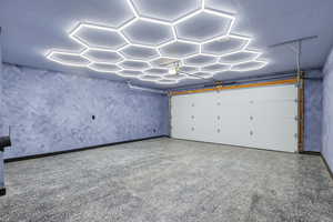 Garage featuring baseboards and a garage door opener