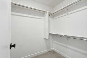 Walk in closet with light colored carpet