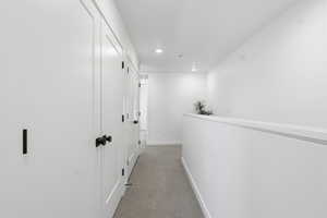 Hall with light carpet and recessed lighting
