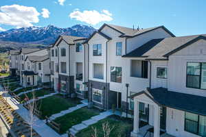Modern inspired farmhouse with board and batten siding, roof with shingles, a residential view, a mountain view, and stone siding