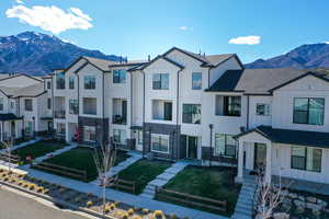View of front of home featuring board and batten siding, a mountain view, a residential view, and a front yard