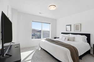 Bedroom with light carpet and baseboards