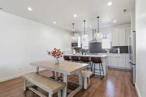 Dining room with recessed lighting and dark wood-style floors