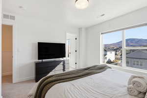 Bedroom featuring light carpet and baseboards