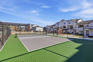 View of tennis court with a residential view and a pergola