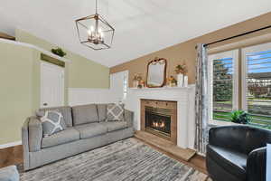 Living area featuring wood finished floors, lofted ceiling, healthy amount of natural light, and a fireplace