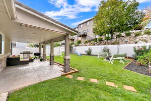 Fenced backyard with a playground and a patio