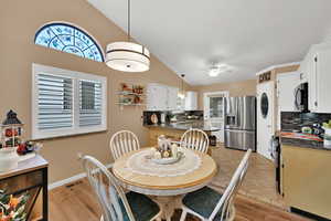 Dining area featuring healthy amount of natural light, vaulted ceiling, ceiling fan, and light tile patterned floors