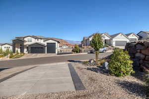View of concrete driveway with a residential view and a mountain view